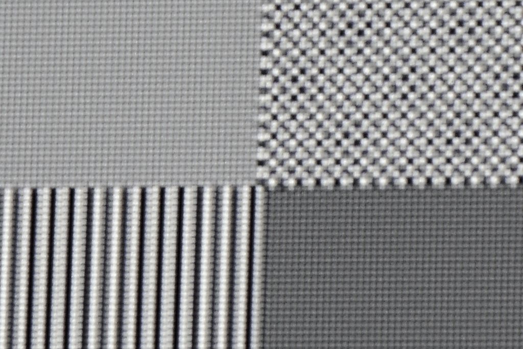 4K-Pixelauflösung: Als nächstes wird ein Schachbrett-Testbild mit einer Auflösung von 3840 x 2160 Pixel zugespielt. Oben links ist jeder einzelne Pixel klar und deutlich abgegrenzt. Allerdings erscheint die gesamte Fläche hellgrau eingefärbt, weil sich durch die eShift-Funktion die schwarzen und weißen Pixel überlagern. Die Folge ist die „Mischfarbe“ Grau. Rechts daneben ist das Schachbrettmuster mit Full-HD-Auflösung zu sehen. Auch hier werden einzelne Pixel des Schachbrettmusters nicht ordentlich dargestellt. Die Ursache liegt hier ebenfalls in der eShift-Technik begründet und der „krummen“ Anzahl der Pixel auf dem DMD. Das Quellsignal lässt sich von 1920 x 1080 Pixel halt nicht gleichmäßig ohne zu „interpolieren“ auf die 2716 x 1528 Pixel hochskalieren. 