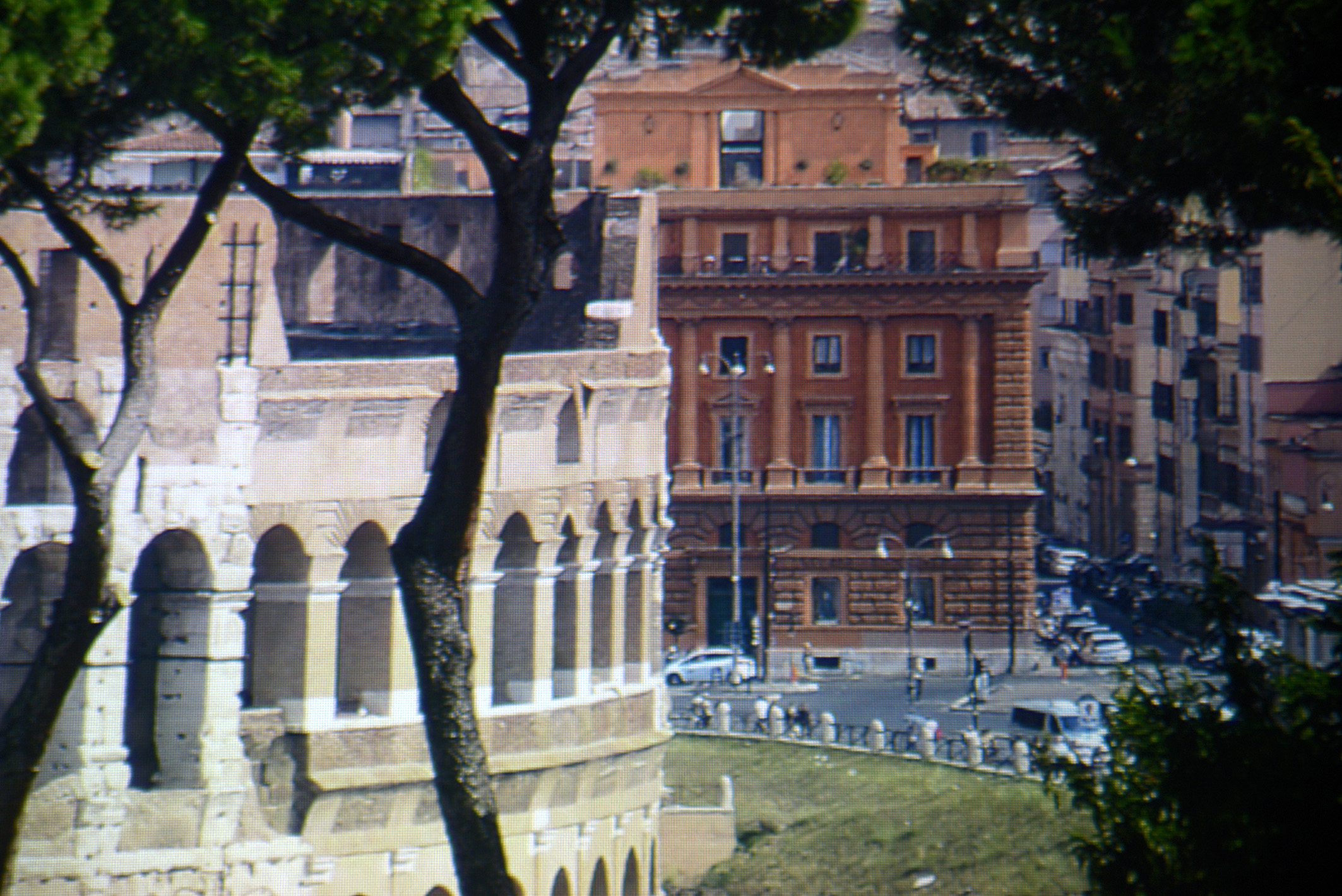 Foto: Michael B. Rehders - Dieser Screenshot zeigt einen kleinen Ausschnitt aus einem 4K-Bildwerk aus Rom. Neben dem Kolosseum steht ein gemauertes Haus in verschiedenen rot/braunen Farbtönen. Die Straßenlaternen davor sind vollständig zu sehen. Selbst der Zaun wird detailreich reproduziert, der das Kolosseum von der Straße abgrenzt. 