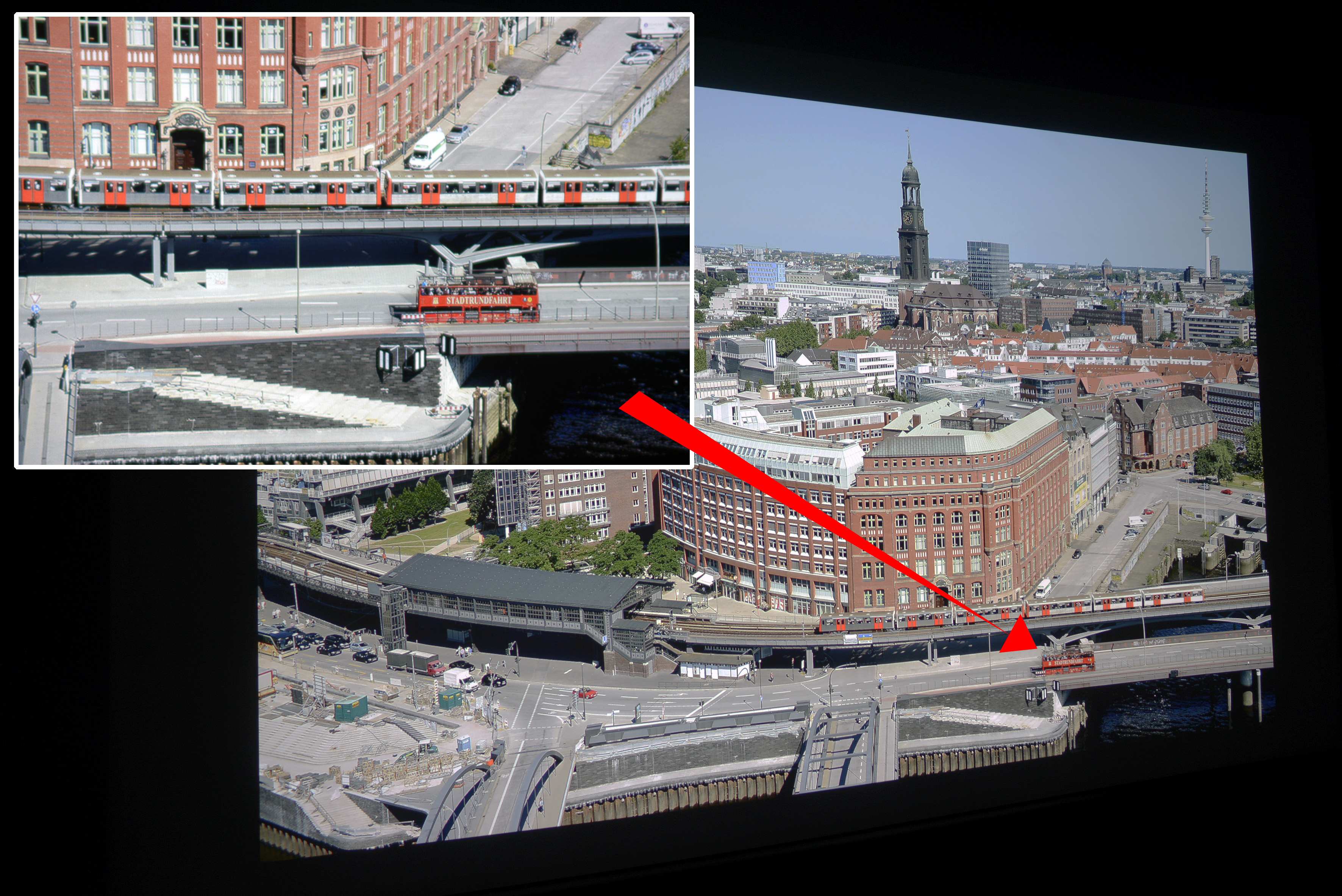 Foto: Michael B. Rehders Das Hamburg Panorama habe ich aus der 21. Etage des Hanseatic Trade Centers geschossen. Auf dem Foto werden die Farben originalgetreu reproduziert. Der leichte Blauverlauf im Himmel gelingt dem W1700 übergangslos mit allen Nuancen. In der Ausschnittsvergrößerung (oben links) wird deutlich, wie hervorragend die Schärfe dieser UHD-Auflösung projiziert wird. Der Schriftzug „STADTRUNDFAHRT“ wird vollständig auf dem roten Doppeldecke abgebildet. Der Asphalt ist farbneutral und die orangenen U-Bahntüren realistisch.